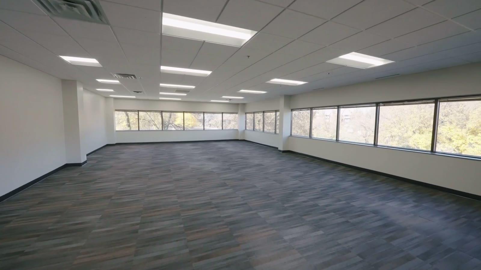 Empty office fit-out with new suspended ceiling, recessed lighting and full-height glazing