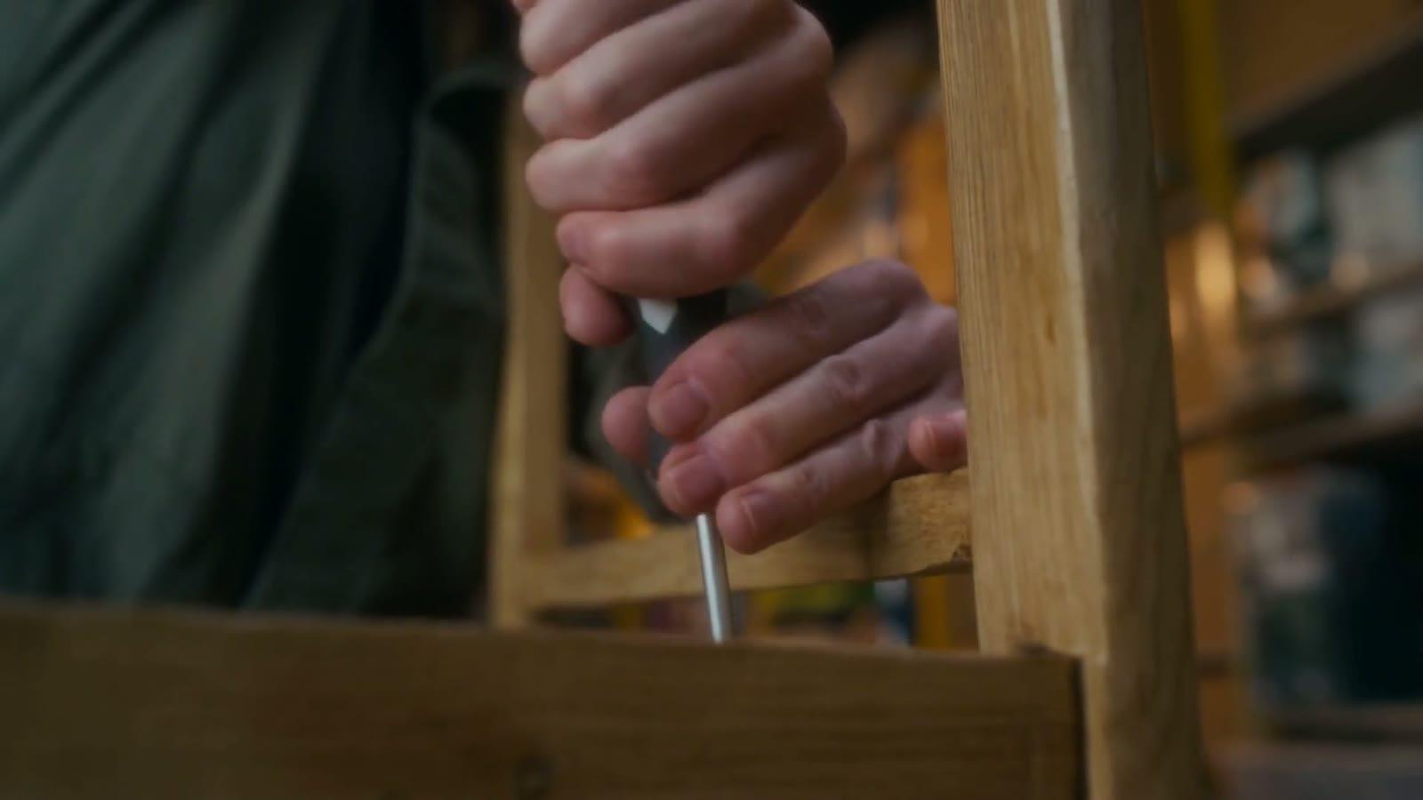 Chisel paring back an old timber frame on the workshop bench