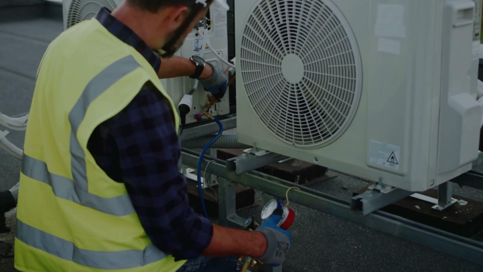 Technician servicing an outdoor condenser unit