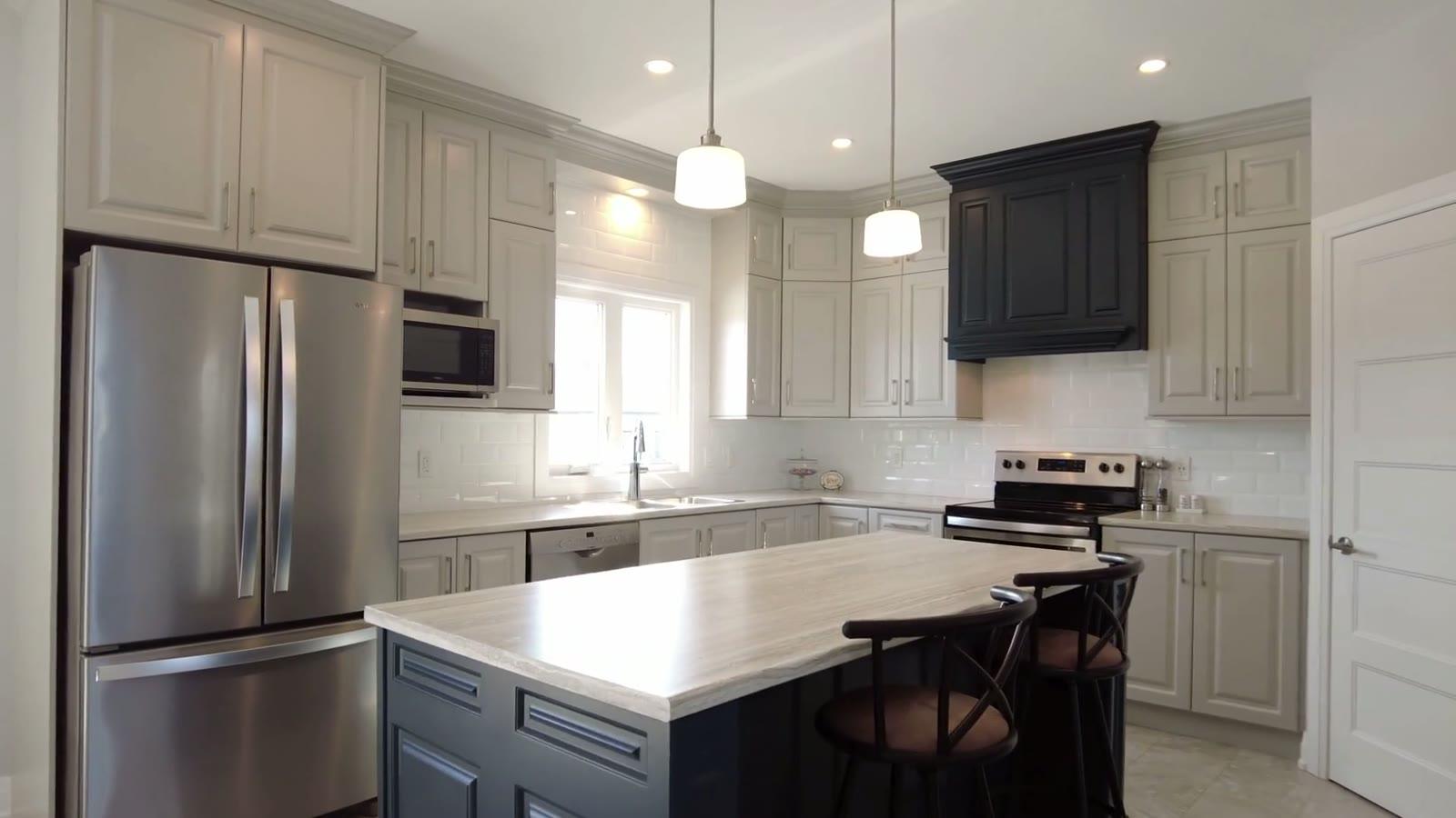 Finished kitchen remodel: grey shaker cabinets, navy island and range hood, subway tile
