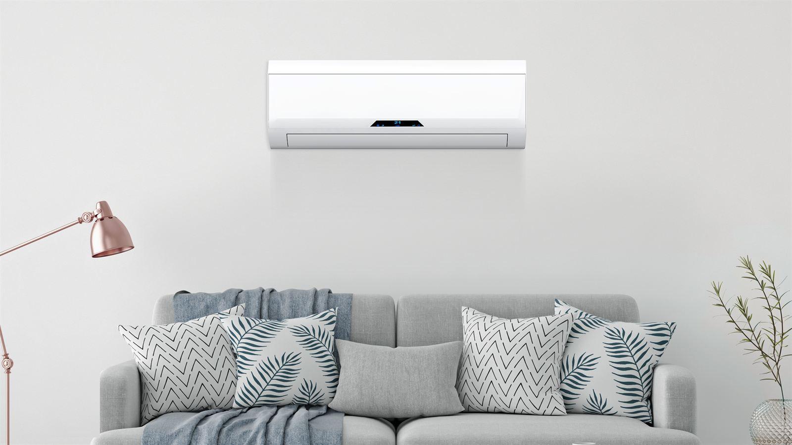 Wall-mounted ductless mini-split head installed above a living room sofa
