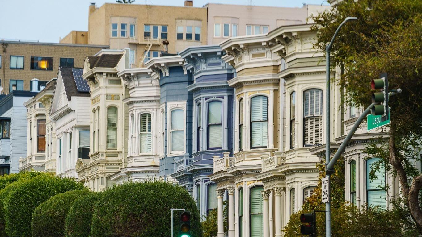 A row of painted Victorian bay windows on a San Francisco street